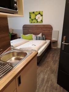 eine Küche mit einem Waschbecken und ein Bett in einem Zimmer in der Unterkunft Hotel M24 - Alle Zimmer mit Küchenzeile in Vechta