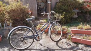 a bike parked in a garden next to potted plants at Cocochi House in Yufuin