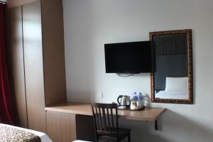 a hotel room with a desk and a mirror at Hotel Rosmerah in Ayer Keroh