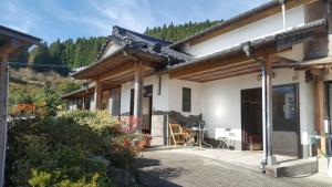 a house in the mountains with a table and chairs at Cocochi House in Yufuin