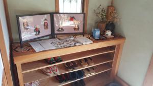 a shelf in a room with shoes on it at Cocochi House in Yufuin