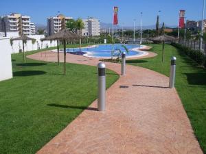 um parque com uma piscina com guarda-sóis em Arenales Playa by Mar Holidays em Arenales del Sol