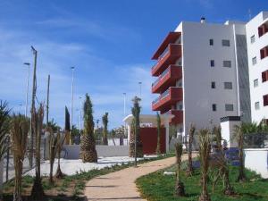 um edifício com palmeiras em frente a um edifício em Arenales Playa by Mar Holidays em Arenales del Sol