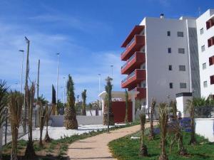 a building with palm trees in front of a building at Arenales Playa by Mar Holidays in Arenales del Sol