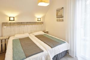 Кровать или кровати в номере Résidence Vacances Bleues Les Jardins d'Arvor