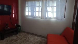 a living room with a red couch and a window at KR Hostel Ilhabela in Ilhabela
