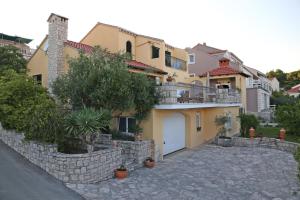 een groot geel huis met een stenen muur bij House 4 You in Lumbarda