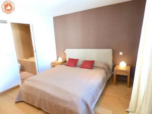 a bedroom with a bed with two red pillows on it at ALC - VC3 - 7 min Palais and 3 min Beaches in Cannes