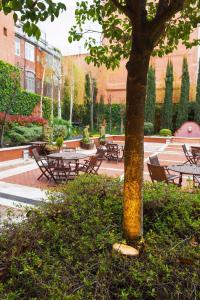 un parque con mesas, bancos y un árbol en Valladolid Recoletos, en Valladolid