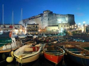 un montón de barcos estacionados frente a un castillo en B&B Miseria e Nobilta', en Nápoles