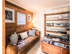 a living room with a leather couch and a coffee table at Sugar Hotel in Cape Town
