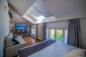 a bedroom with a bed and a couch and a window at Marina Centro Suite in Rimini