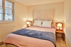 een slaapkamer met een groot bed met twee lampen bij Gites La Maison Mann in Sand