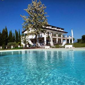 a large swimming pool with a house in the background at B&B Radici24 in Battipaglia