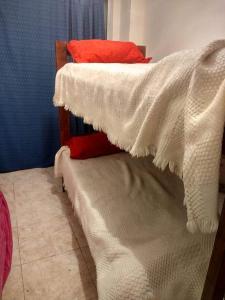 a bedroom with two bunk beds with white blankets at el cabo frente al mar in Mar del Plata
