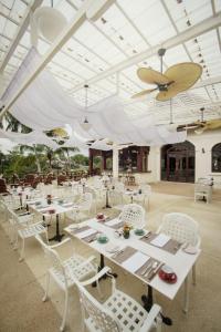 a restaurant with white tables and chairs and a ceiling at Le Bel Air Resort Luang Prabang in Luang Prabang