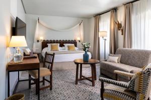 a hotel room with a bed and a couch and a table at Parador de Arcos de la Frontera in Arcos de la Frontera