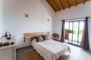 ein Schlafzimmer mit einem Bett und einem großen Fenster in der Unterkunft Casa do Nuno T2 in Canto