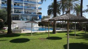 a resort withiki umbrellas and a swimming pool at Skol 617 Beachfront Two-bedrooms Duplex With Sea Views in Marbella