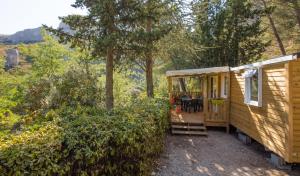 a cabin in the woods with a table and chairs at Camping de la Vallée Heureuse in Orgon