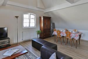 een woonkamer met een tafel, stoelen en een bank bij Gites La Maison Mann in Sand
