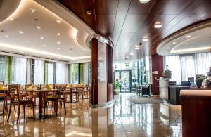 a restaurant with wooden tables and chairs and windows at Hotel Stoiser Graz -Parkplatz inbegriffen! in Graz