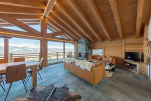 a living room with a couch and a table at Oak Tree Chalet - on the ski slope - luxury! in Nendaz