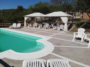 una piscina con sillas y un cenador en Cabañas El Mirador en Embalse