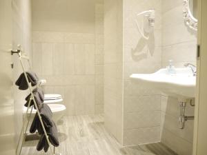 La salle de bains est pourvue d'un lavabo et de toilettes. dans l'établissement L'Ortodellerose, à Alba