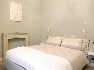 um quarto com uma cama branca e uma mesa em L'Ortodellerose em Alba