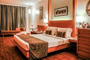 een hotelkamer met een groot bed en een bank bij Hotel Heritage formerly known as Comfort Inn Heritage in Mumbai