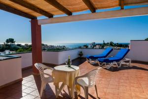 a patio with chairs and a table with a bottle of wine at Los Arcos in Nerja
