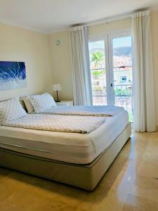 um quarto com uma cama grande e uma janela grande em La Casa Canaria em La Playa de Arguineguín