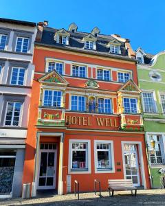 ヴィットリッヒにあるHotel Well Garniのホテルの建物の前にベンチがあります。