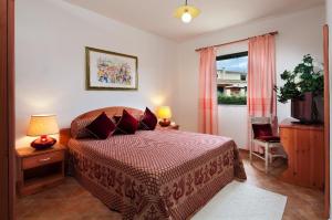 a bedroom with a bed and a window and a television at Appartamenti Le Ginestre e Gli Oleandri in Cala Liberotto