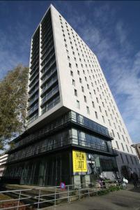 Um edifício alto com um sinal amarelo à frente. em Hotel New Kit em Amsterdã