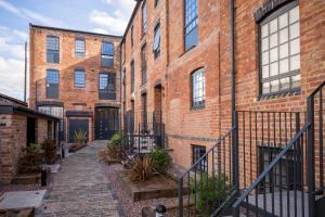 an alley in a brick building with plants at Elliot Oliver - Modern 2 Bedroom Town Centre Apartment in Cheltenham