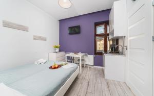 sypialnia z łóżkiem i fioletową ścianą w obiekcie K12 Apartments w Krakowie