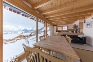 a dining room with a table and a large window at Chalet Nid Blanc in Nendaz