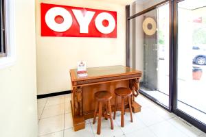 une table et deux tabourets devant une fenêtre dans l'établissement Super OYO Capital O 217 A1 Hotel, à Surabaya