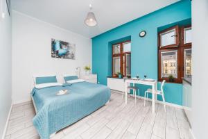 Dormitorio azul con cama y mesa en K12 Apartments, en Cracovia