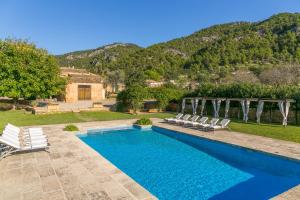 a swimming pool with chairs and a house at Historic House in Mallorca Up To 12 Guests in Andratx