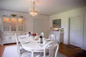 uma sala de jantar com uma mesa branca e cadeiras em Olsbacka Gård em Falun