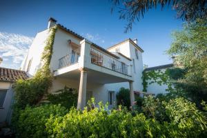 a white house with a balcony on top of it at Hotel La Fuente de la Higuera in Ronda