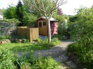 einen Garten mit einem Pavillon neben einem Zaun in der Unterkunft Enzkreisspitze Garten in Neuenbürg