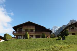 a house on top of a grassy hill at Alpage: Residence Brevent in Les Houches