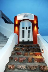 a set of stairs leading to a building with a white door at Sunset Hotel in Firostefani