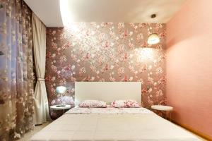 a bedroom with a bed with a floral wallpaper at Apartment 13А Holosiivska Street in Kyiv