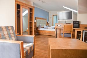 Sala de estar con dormitorio con cama y mesa en Hotel am Wiesenhang - Garni, en Bad Kohlgrub