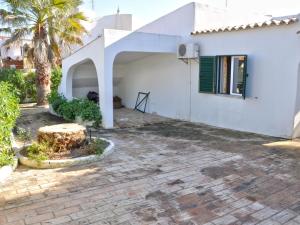 a white house with a palm tree in front of it at Tranquil Villa in Vilamoura with Private Swimming Pool in Vilamoura